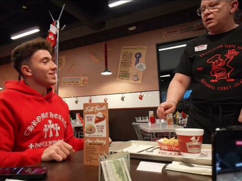 Waitress Tammy reacts as a creator tells her the $1,000 cash tip on the table is hers, inside a National Coney Island restaurant.
