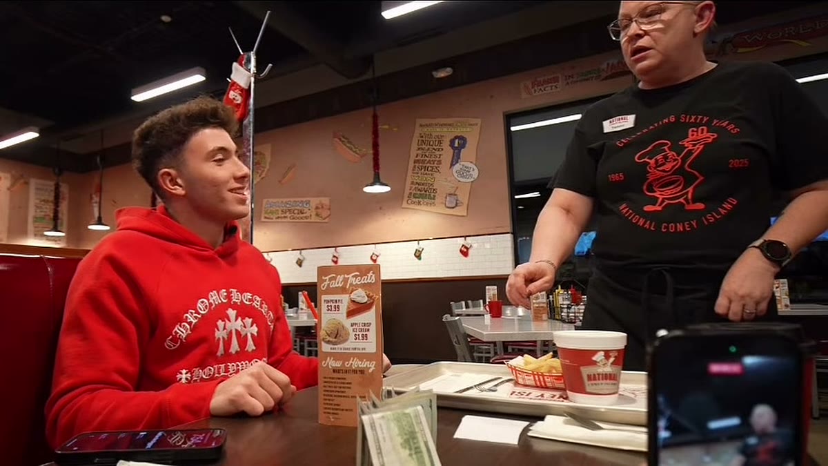 Waitress Tammy reacts as a creator tells her the $1,000 cash tip on the table is hers, inside a National Coney Island restaurant.
