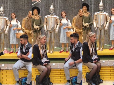 A couple sits in front of a Wizard of Oz display.