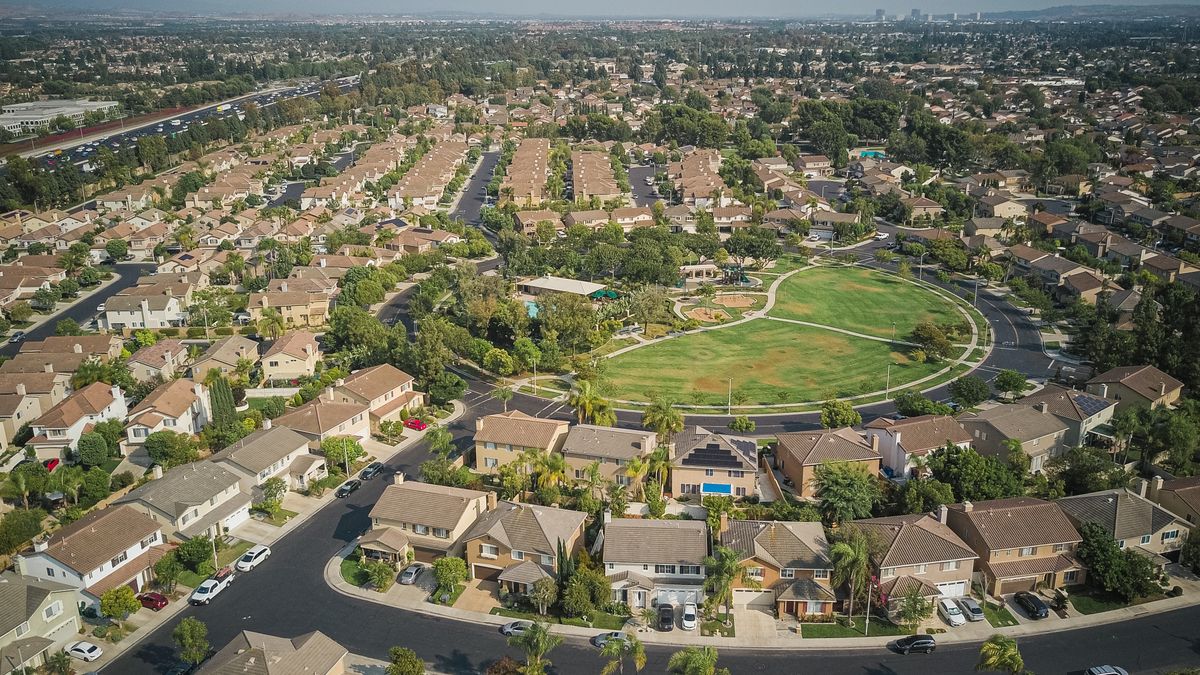 Aerial view of a suburban HOA community with homes and central park